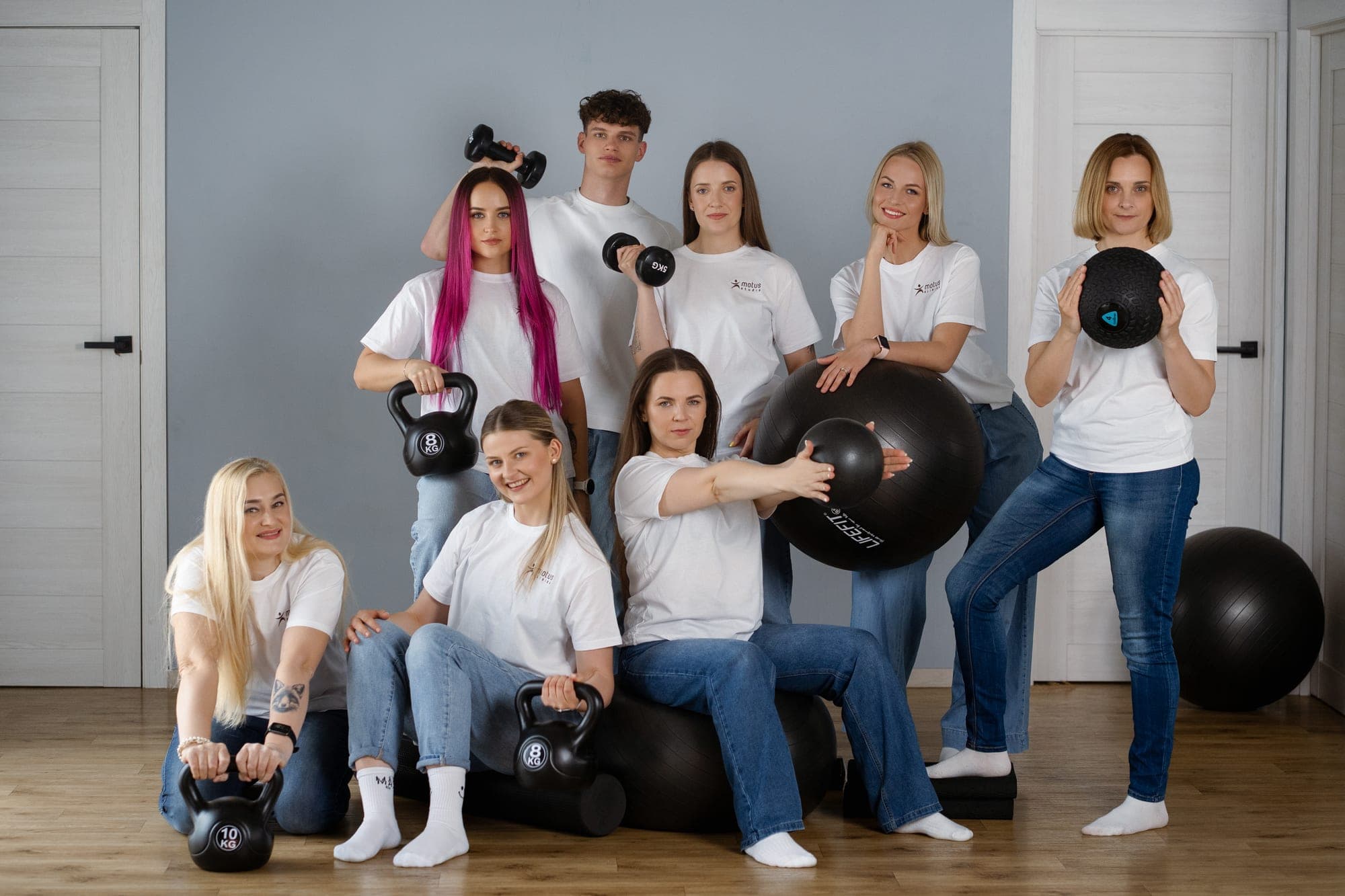 Motus komanda studijoje su svarsčiais, kamuoliais ir hanteliais